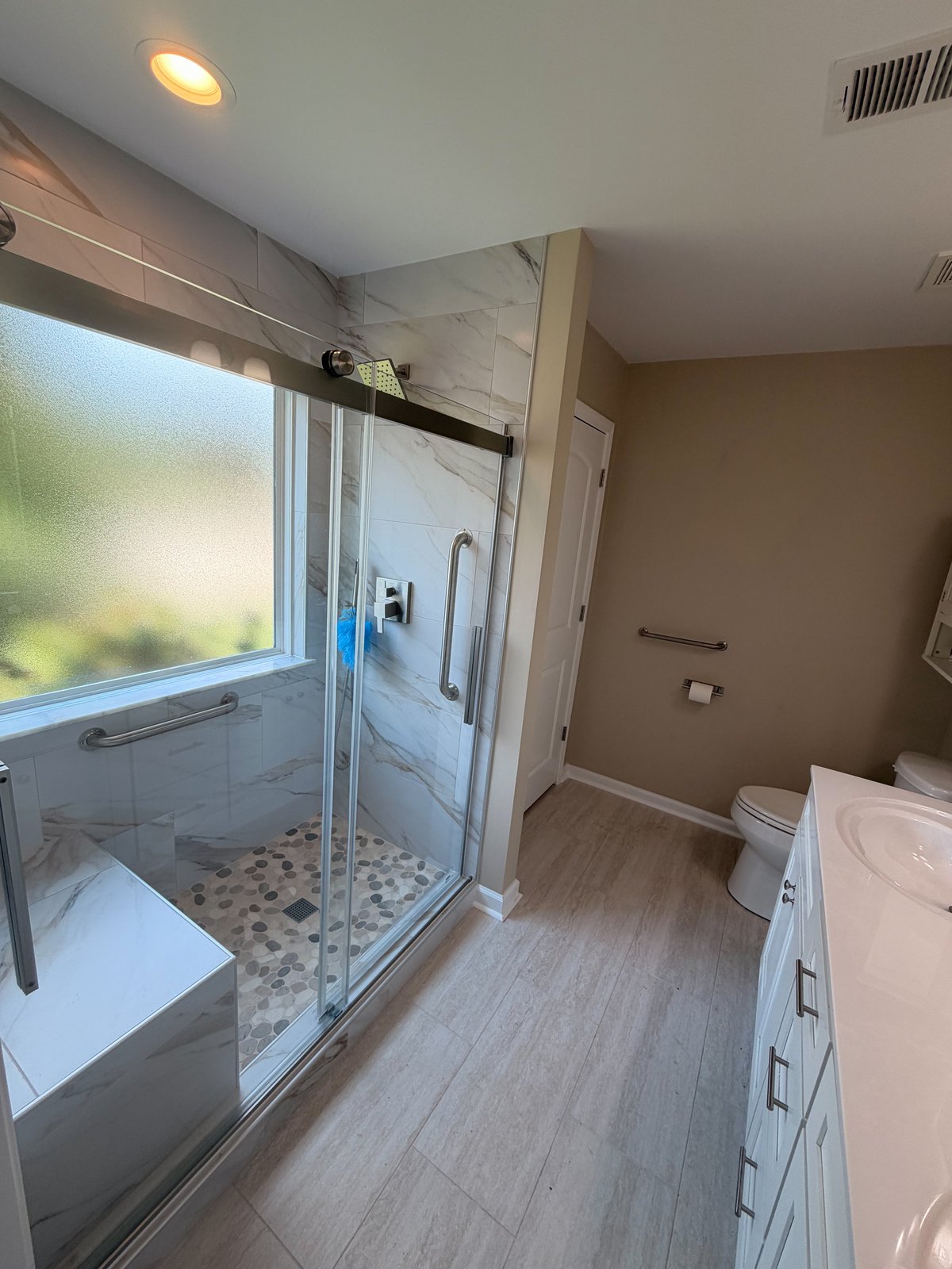 Bathroom after JICON remodel — walk-in glass shower with marble tile