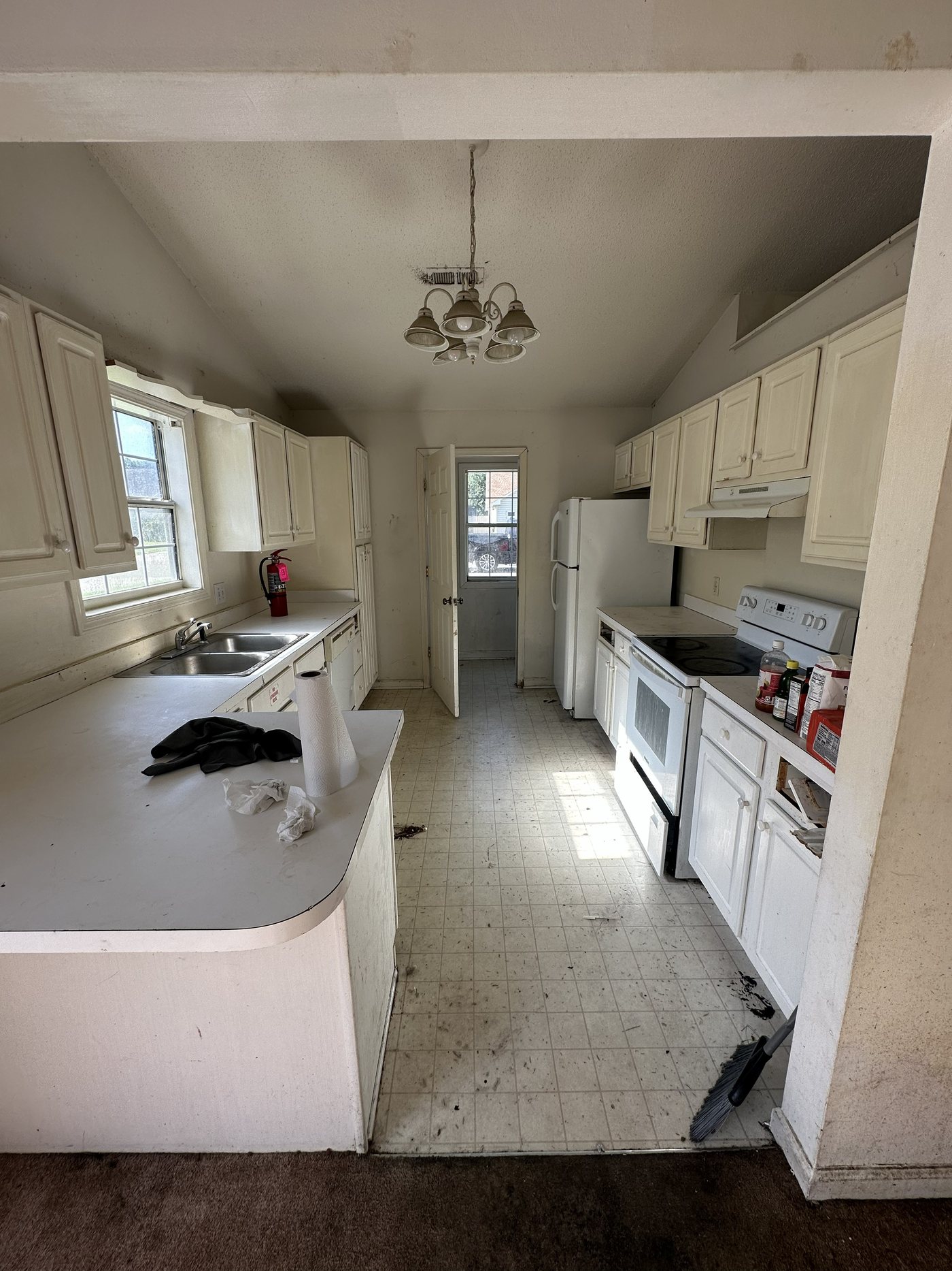 Kitchen before JICON remodel — dated cabinets and worn floor